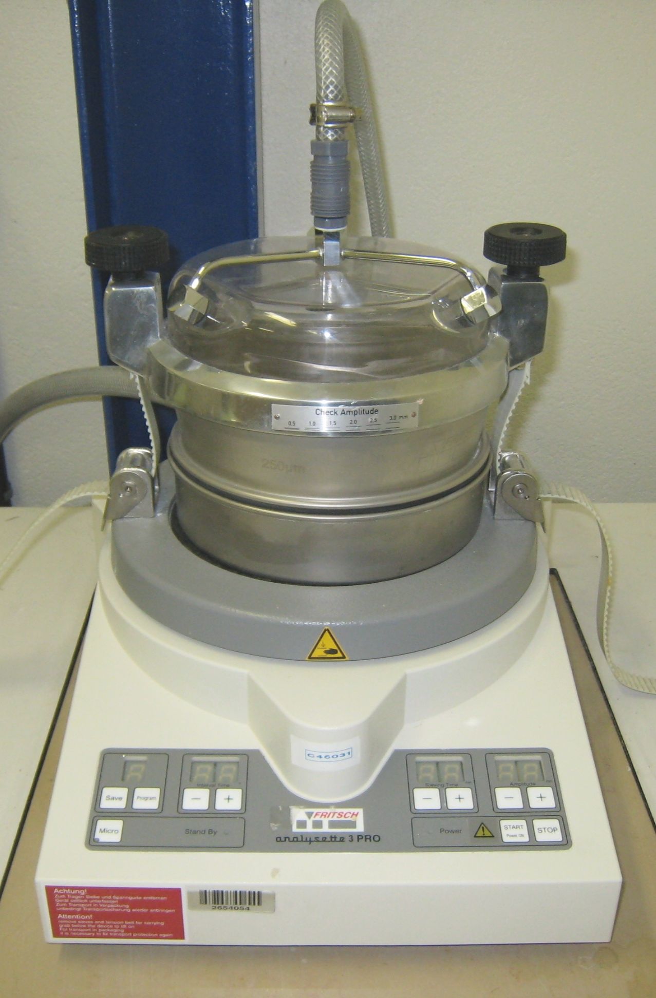Laboratory vibrating sieve apparatus with a clamped test sieve and wet-sieving connections